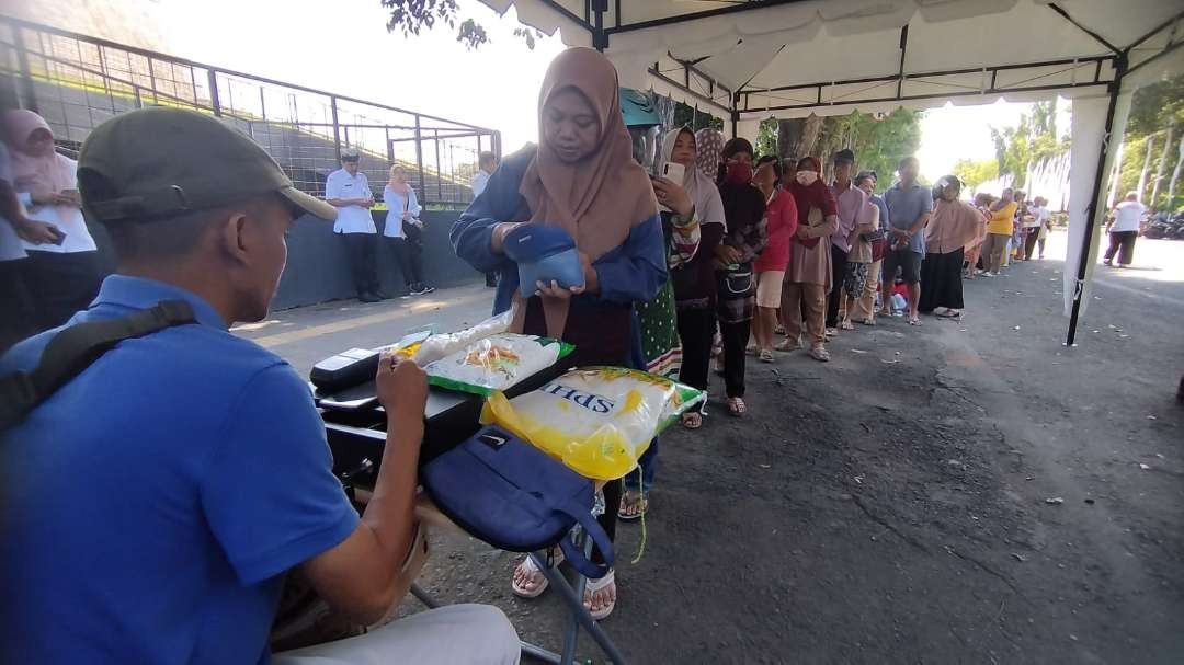 Puluhan warga antre membeli beras dan komoditi lain pada operasi pasar yang digelar di dean Gedung Juang Banyuwangi. (Foto: Muh Hujaini/Ngopibareng.id)