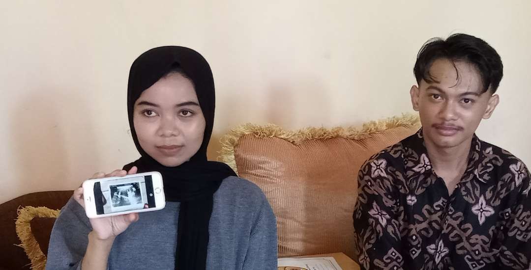 Anggota KPPS yang mengalami keguguran di dampingi suaminya menunjukan foto hasil USG (Foto: Khoirul Huda/Ngopibareng.id)