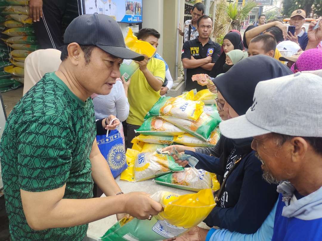 Bupati Lamongan, Yuhronur Efendi sempat ikut melayani penjualan beras saat operasi pasar murah(Foto : Imron Rosidi/ngooibareng.id)