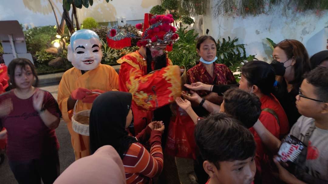 Sejumlah warga berebut mendapat permen dalam acara perayaan Imlek Cap Go Meh di Balai Kota, Surabaya, Minggu 25 Februari 2024. (Foto: Fariz Yarbo/Ngopibareng.id)