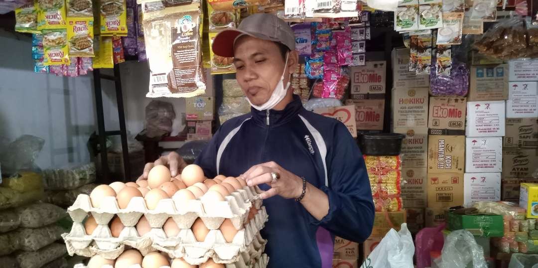 Penjual telur ayam di Pasar Baru Tuban sedang melayani pembeli (Foto: Khoirul Huda/Ngopibareng.id)