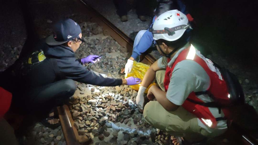 Pencarian bagian tubuh korban yang tercecer di rel kereta api.(Foto Deni Lukmantara/Ngopibareng)