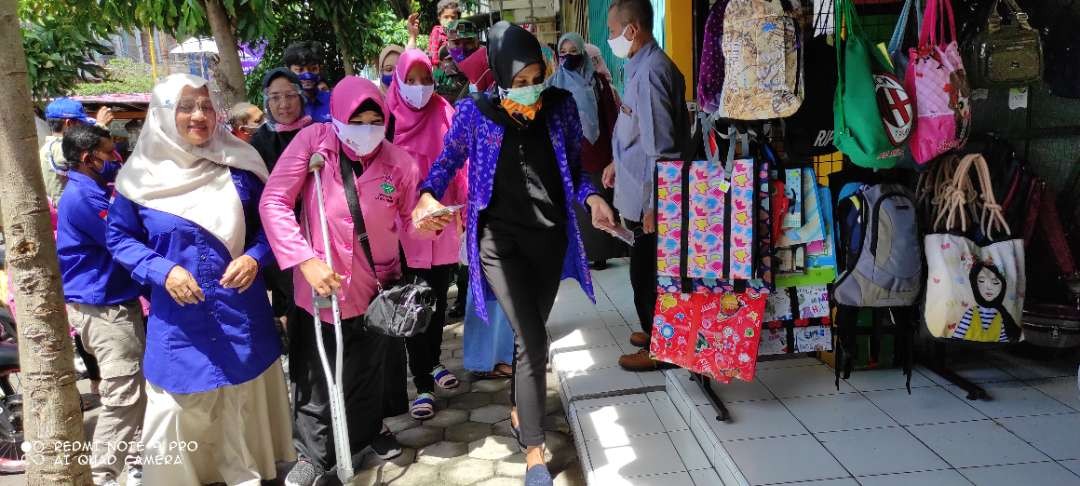 Ilustrasi. Istri Walikota Kediri, Feronica dampingi penyandang disabilitas bagikan masker. (Foto: Fendhy Plesmana/Ngopibareng.id)