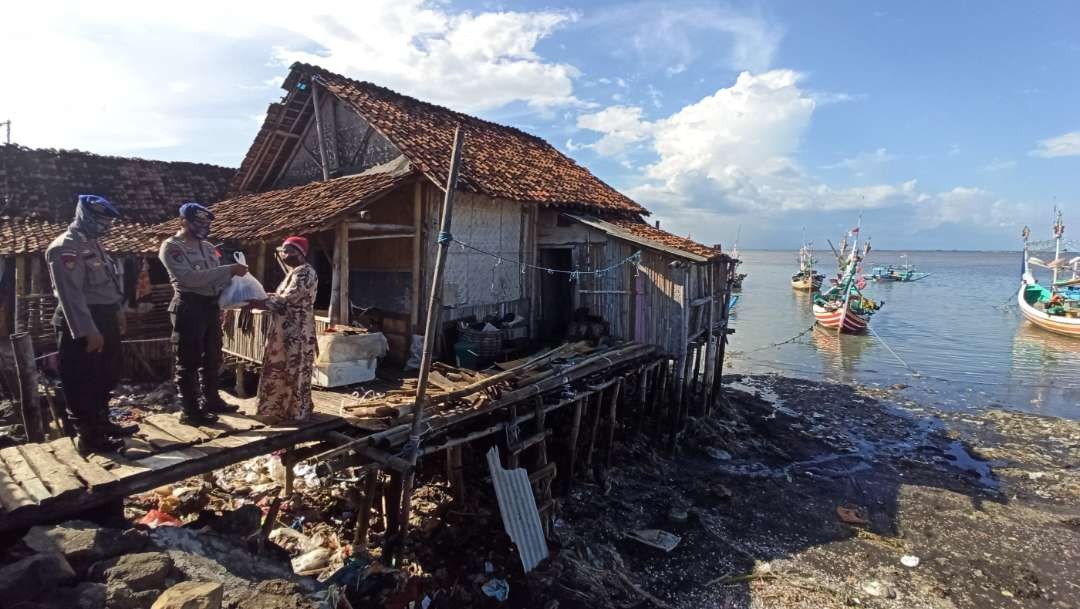 Petugas Polairud Banyuwangi menyerahkan bantuan kepada nelayan di Muncar, Banyuwangi. (Foto: Hujaini/Ngopibareng.id)