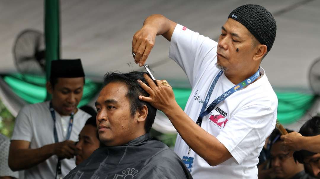 Warga mengikuti kegiatan potong rambut gratis di Masjid Agung Al-Akbar, Surabaya, Senin 11 Maret 2024. (Foto: Fariz Yarbo/Ngopibareng.id)