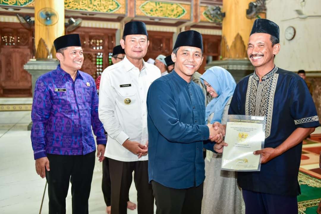 Wamen ATR/Waka BPN) Raja Juli Antoni didampingi Bupati Lamongan Yuhronur Efendi menyerahkan sertifikat wakaf kepada salah satu penerima. (Foto: Imron Rosidi/Ngopibareng.id)