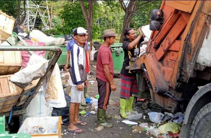 Di saat masyarakat menikmati cuti bersama  untuk lebaran tukang sampah tetap bekerja seperti biasa menyapu jalan fan mengumpulkan sampah dari sampah dari rumah ke rumah ( foto: Asmanu Sudarso/ngopibareng.id)b