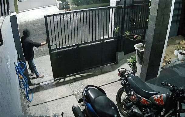Pelaku dengan santai membuka pintu pagar rumah polisi Bondowoso hendak mencuri motor.(Foto: Guido Tangkapan Layar)