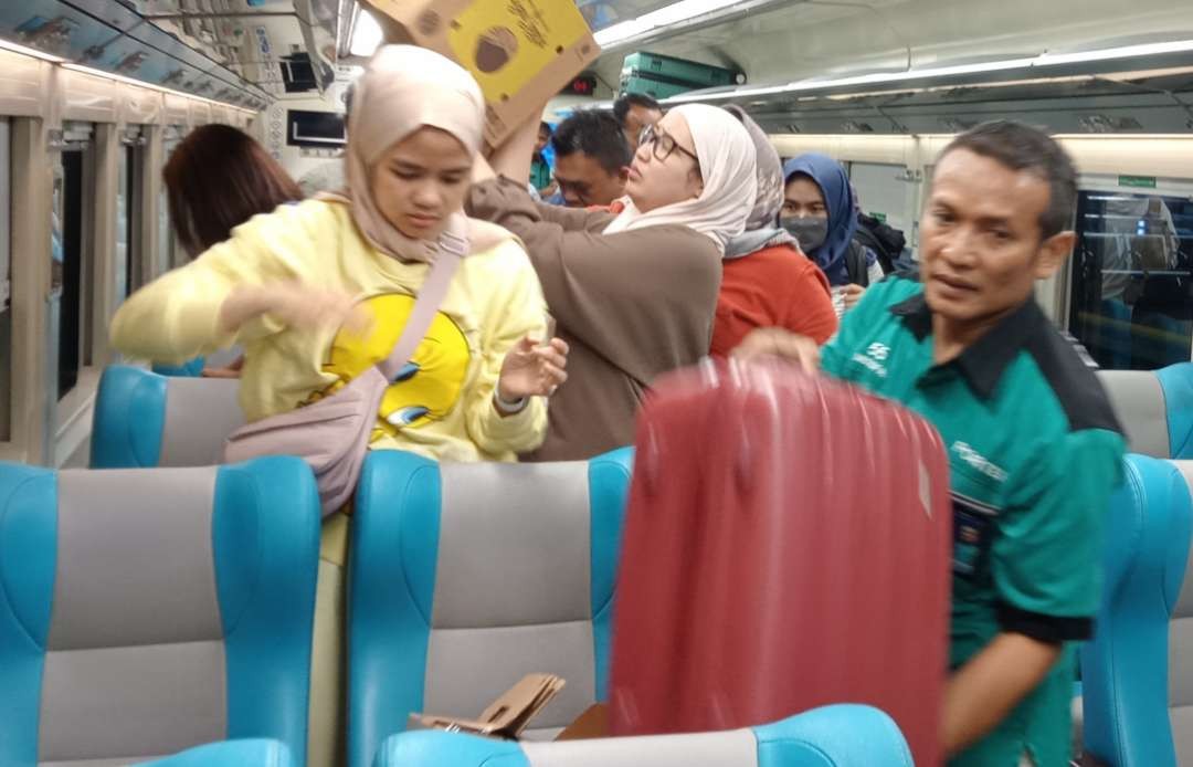 Seorang kuli panggul barang milik penumpang KAI di Stasiun Gambir Jakarta, harus ramah dan murah senyum (Foto: Asmanu Sudarso/ngopibareng.id)