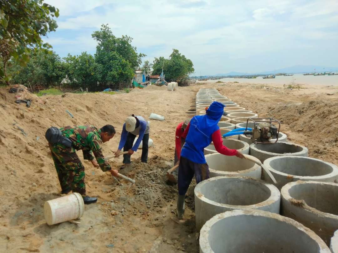 Babinsa Koramil 0811/12 Bancar membantu masyarakat membuat tanggul laut (Foto: Dok Babinsa Bancar)