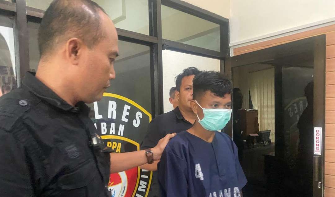 Pelaku begal payudara keluar dari ruangan usai dimintai keterangan oleh penyidik Satreskrim Polres Tuban (Khoirul Huda/Ngopibareng.id)