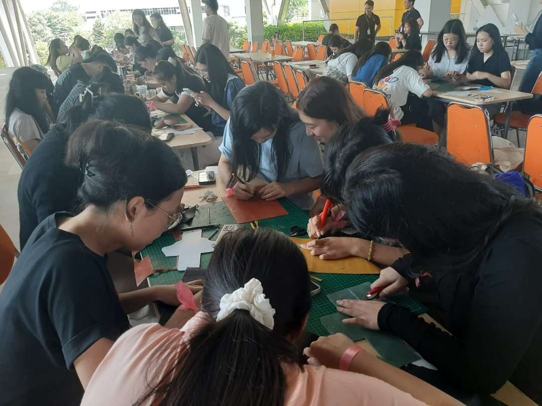 Para mahasiswa Petra Christian University (PCU) Surabaya, saat membuat card holder dari premium leather, pada peringatan Hari Seni Sedunia. (Foto: Julianus Palermo/Ngopibareng.id)