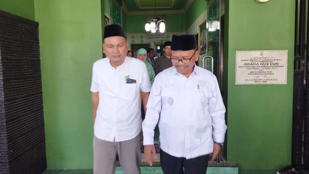 Sugirah meninggalkan kantor DPC PKB didampingi Ketua DPC PKB, KH Abdul Malik Syafaat. (Foto: Muh Hujaini/Ngopibareng.id)