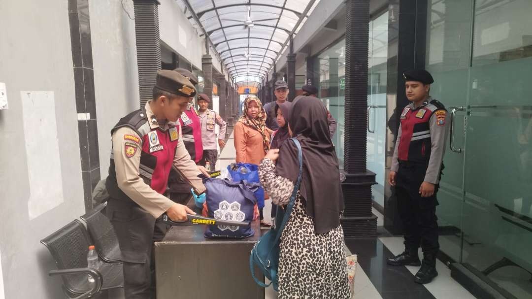 Polisi melakukan pemeriksaan barang bawaan penumpang dengan menggunakan metal detector. (Foto: Muh Hujaini/Ngopibareng.id)